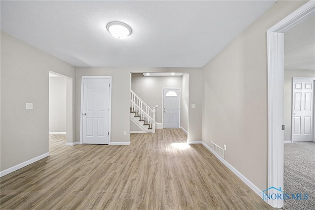 145 E Crocker St, Fostoria, OH 44830 - unfurnished room featuring wood finished floors and stairway