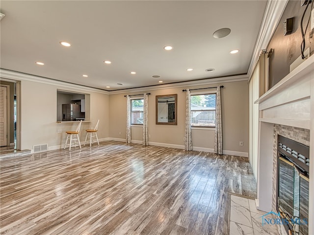 1323 Richland St, Maumee, OH 43537 - unfurnished living room featuring crown molding, light wood-style floors, a fireplace, and recessed lighting