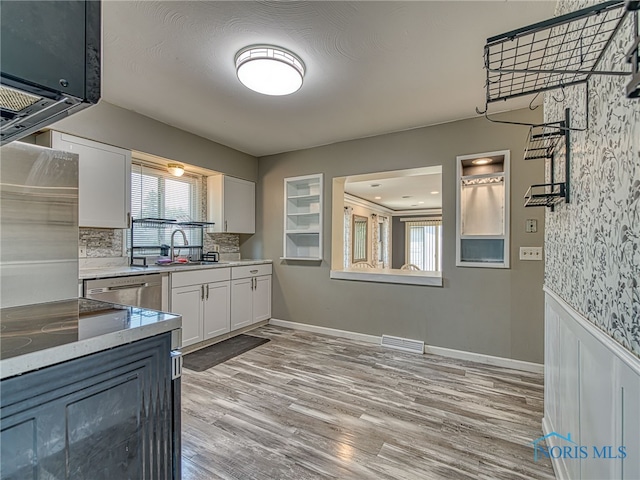 1323 Richland St, Maumee, OH 43537 - kitchen featuring stainless steel dishwasher, white cabinetry, light wood-style floors, light stone counters, and backsplash