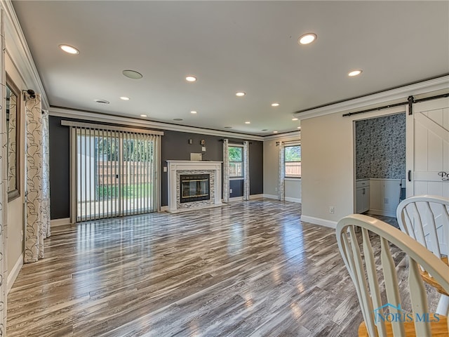 1323 Richland St, Maumee, OH 43537 - unfurnished living room with ornamental molding, a barn door, wood finished floors, recessed lighting, and a fireplace