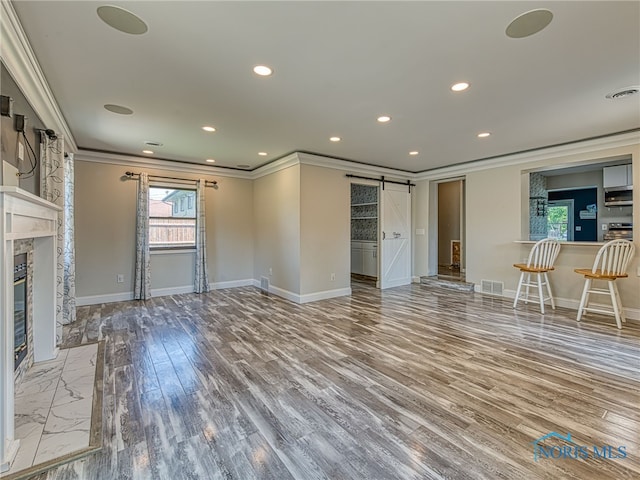 1323 Richland St, Maumee, OH 43537 - unfurnished living room with ornamental molding, a barn door, wood finished floors, recessed lighting, and a fireplace with flush hearth