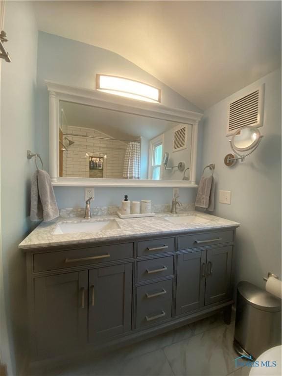 2950 Darlington Rd, Toledo, OH 43606 - bathroom featuring lofted ceiling, double vanity, and marble look tile flooring