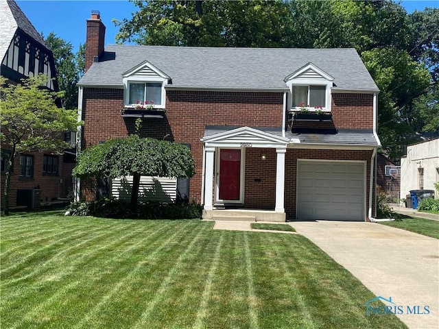 2950 Darlington Rd, Toledo, OH 43606 - view of front facade featuring an attached garage, brick siding, and a front lawn