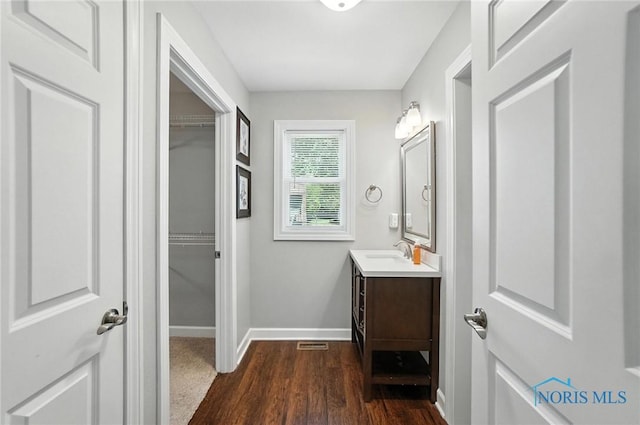 845 Oak Knoll Dr, Perrysburg, OH 43551 - bathroom featuring vanity, wood finished floors, and a walk in closet