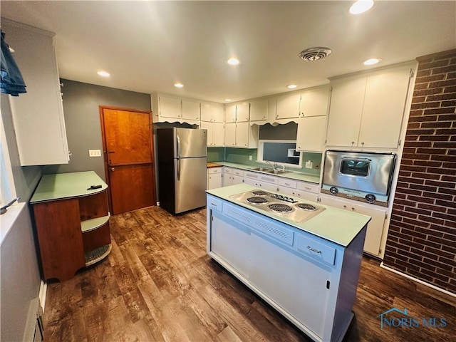 714 Westwood Dr, Defiance, OH 43512 - kitchen featuring freestanding refrigerator, electric stovetop, oven, dark wood-style flooring, and white cabinets