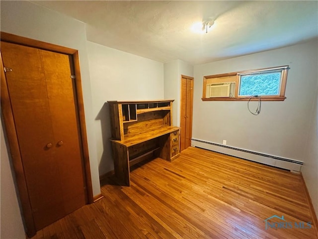 714 Westwood Dr, Defiance, OH 43512 - unfurnished bedroom with baseboard heating, hardwood / wood-style flooring, and a closet