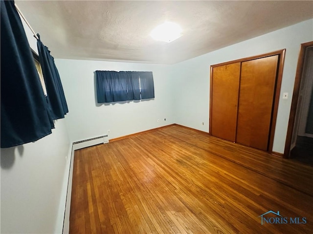 714 Westwood Dr, Defiance, OH 43512 - unfurnished bedroom with hardwood / wood-style floors and baseboard heating