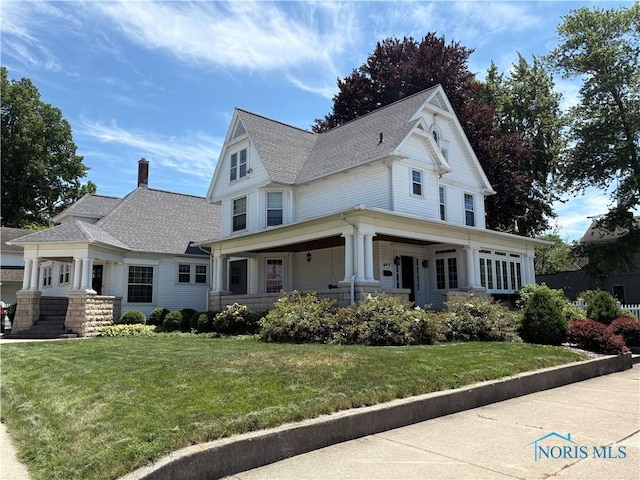 643 S Clinton St, Defiance, OH 43512 - victorian home with a porch, a chimney, a front yard, and a shingled roof