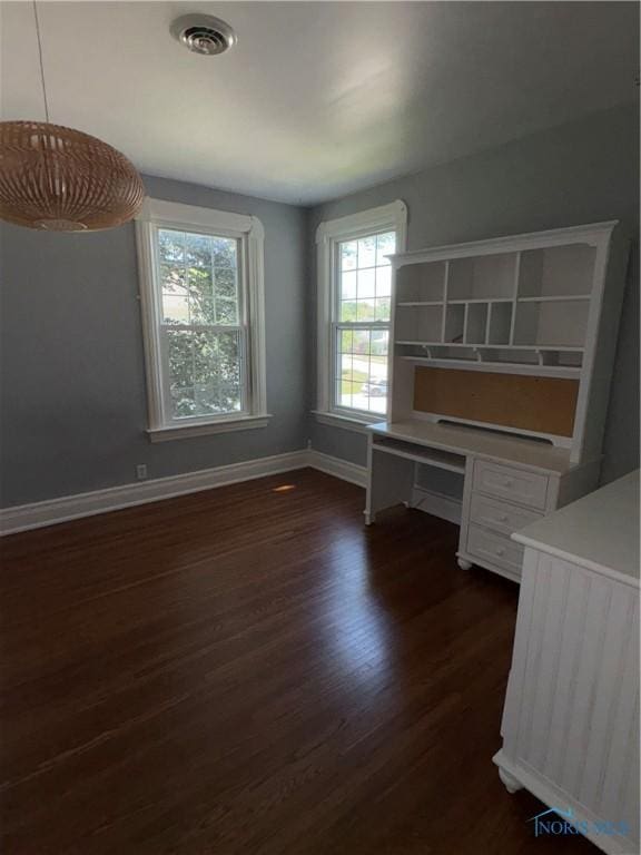 643 S Clinton St, Defiance, OH 43512 - unfurnished bedroom featuring dark wood finished floors and multiple windows