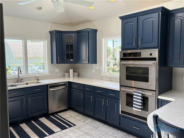 643 S Clinton St, Defiance, OH 43512 - kitchen with appliances with stainless steel finishes, blue cabinets, light countertops, and backsplash