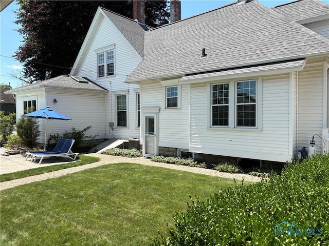 643 S Clinton St, Defiance, OH 43512 - rear view of house with a shingled roof, a chimney, and a yard