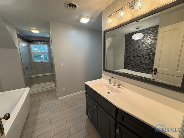 643 S Clinton St, Defiance, OH 43512 - full bath with a shower stall, vanity, a freestanding bath, and wood finished floors