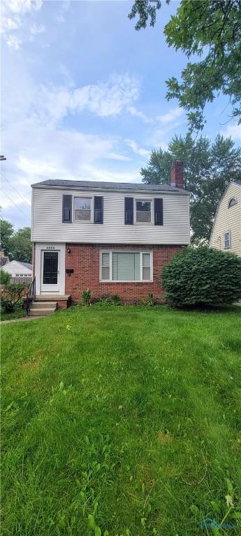 2550 Secor Rd, Toledo, OH 43606 - view of front of home with entry steps, brick siding, a chimney, and a front yard