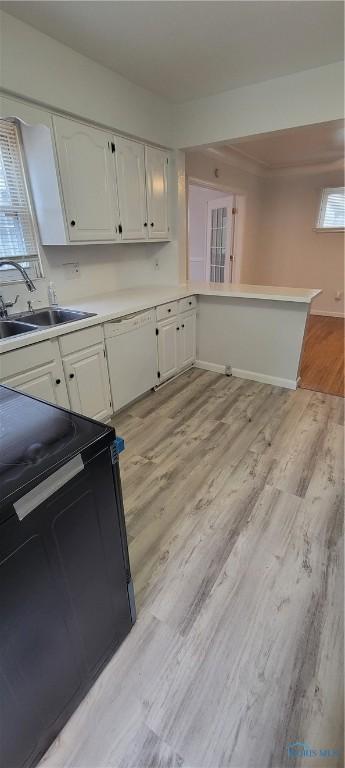 2550 Secor Rd, Toledo, OH 43606 - kitchen featuring range, white cabinetry, light wood-style floors, light countertops, and a peninsula