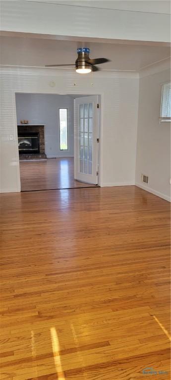 2550 Secor Rd, Toledo, OH 43606 - unfurnished living room with light wood-style floors, a glass covered fireplace, and ceiling fan