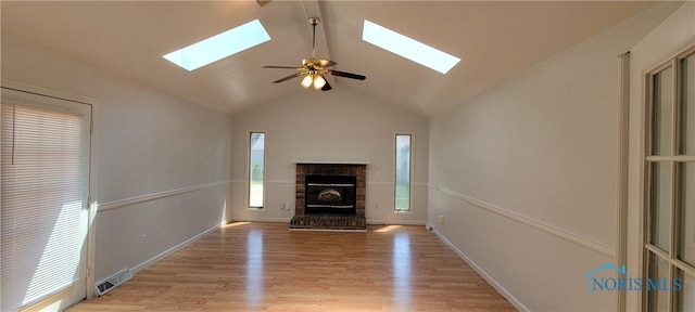 2550 Secor Rd, Toledo, OH 43606 - unfurnished living room featuring a skylight, vaulted ceiling, a fireplace, light wood-type flooring, and a ceiling fan