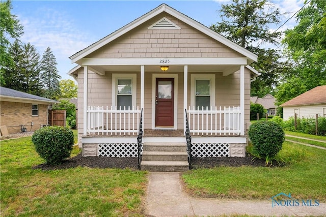 2825 N Mccord Rd, Toledo, OH 43615 - bungalow-style home featuring covered porch and a front yard