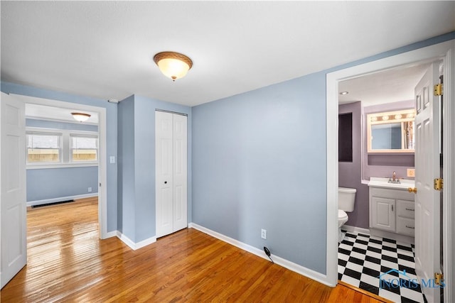 2825 N Mccord Rd, Toledo, OH 43615 - unfurnished bedroom featuring a closet, light wood finished floors, and ensuite bath