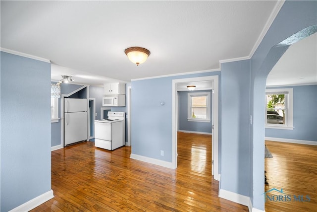 2825 N Mccord Rd, Toledo, OH 43615 - kitchen featuring white appliances, hardwood / wood-style floors, arched walkways, white cabinetry, and ornamental molding
