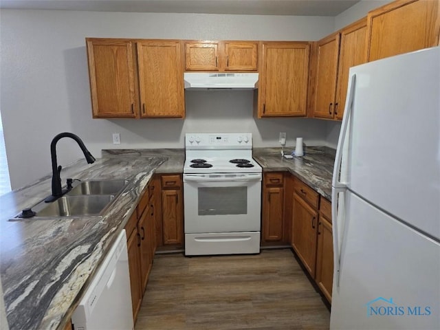 1311 Fitchland Ave, Toledo, OH 43606 - kitchen featuring white appliances, under cabinet range hood, brown cabinetry, dark wood-style flooring, and a peninsula