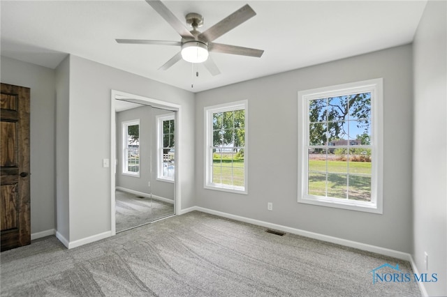 unfurnished bedroom with carpet floors, a ceiling fan, and a closet