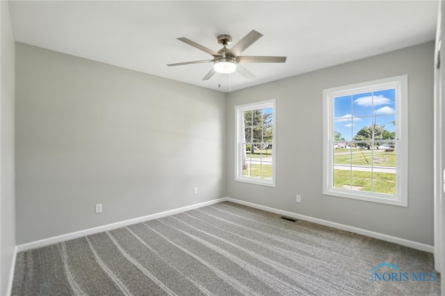 unfurnished room with a ceiling fan and carpet