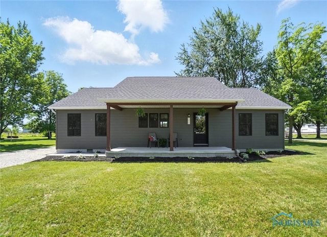 rear view of property featuring a lawn, covered porch, and a shingled roof