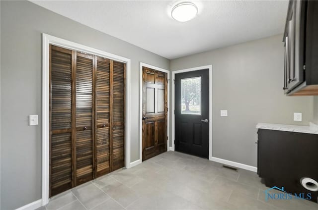 entrance foyer with baseboards and light tile patterned floors