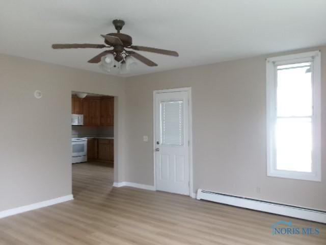 530 N Taft Ave, Ottawa, OH 45875 - unfurnished living room featuring a baseboard heating unit, light wood-type flooring, and a ceiling fan