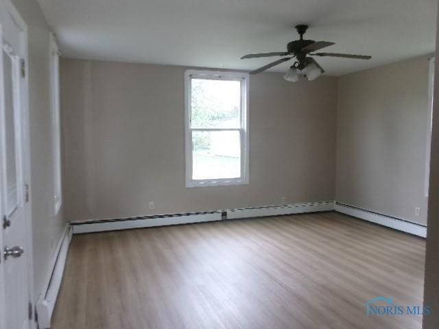 530 N Taft Ave, Ottawa, OH 45875 - empty room with a baseboard heating unit, wood finished floors, and a ceiling fan