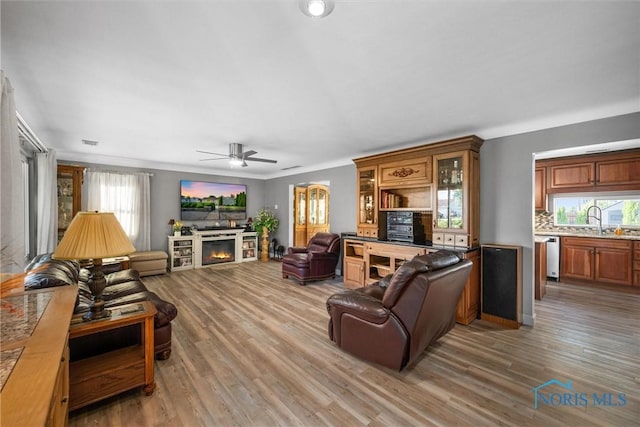855 Strotz Dr, Toledo, OH 43612 - living room with ceiling fan, wood finished floors, and a warm lit fireplace