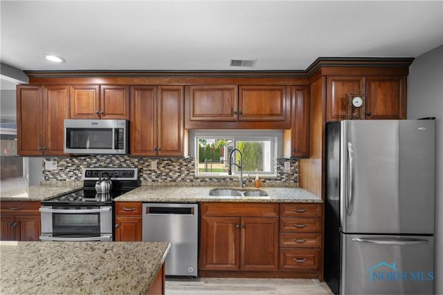 855 Strotz Dr, Toledo, OH 43612 - kitchen with appliances with stainless steel finishes, light wood finished floors, light stone countertops, decorative backsplash, and recessed lighting