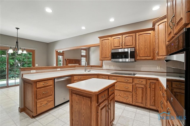 8076 Trent Lock Dr, Waterville, OH 43566 - kitchen featuring stainless steel appliances, a peninsula, light countertops, brown cabinetry, and a center island