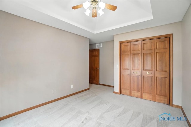 8076 Trent Lock Dr, Waterville, OH 43566 - unfurnished bedroom with light colored carpet, ceiling fan, a raised ceiling, and a closet