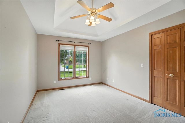 8076 Trent Lock Dr, Waterville, OH 43566 - spare room featuring light carpet, a raised ceiling, and a ceiling fan
