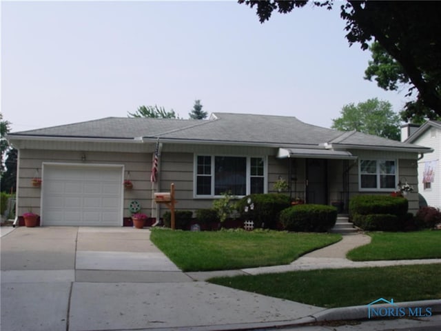 2554 108th St, Toledo, OH 43611 - view of front of house featuring driveway, a garage, and a front yard