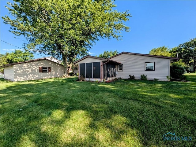 209 Hawthorn Dr, Archbold, OH 43502 - rear view of house with a yard and a sunroom