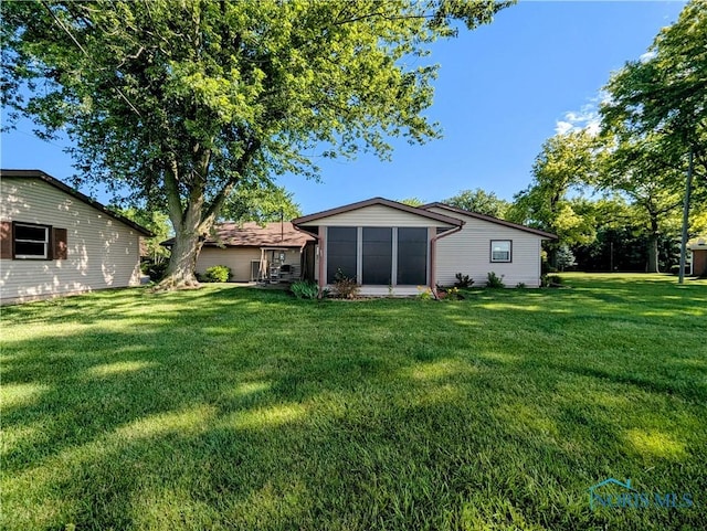 209 Hawthorn Dr, Archbold, OH 43502 - rear view of property with a lawn and a sunroom