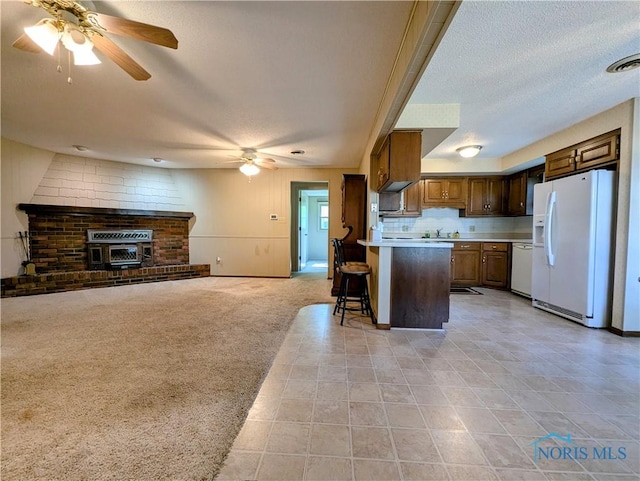 209 Hawthorn Dr, Archbold, OH 43502 - kitchen featuring white appliances, ceiling fan, open floor plan, a peninsula, and a breakfast bar area