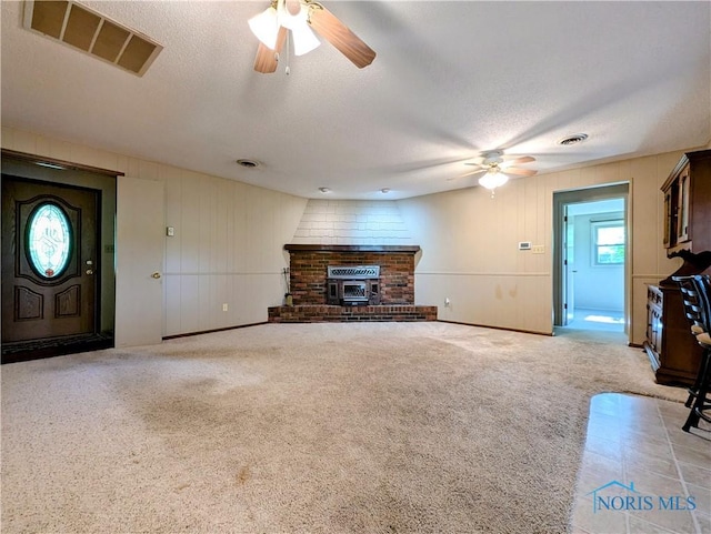 209 Hawthorn Dr, Archbold, OH 43502 - unfurnished living room with ceiling fan, a textured ceiling, a brick fireplace, and carpet flooring