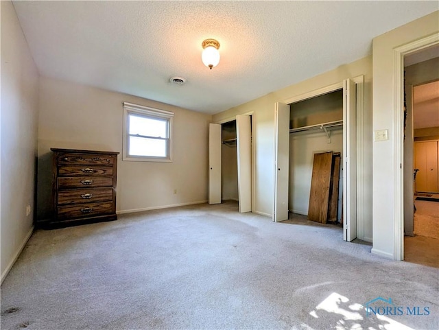 209 Hawthorn Dr, Archbold, OH 43502 - unfurnished bedroom with two closets, carpet flooring, and a textured ceiling