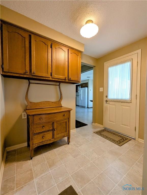 209 Hawthorn Dr, Archbold, OH 43502 - foyer entrance featuring a textured ceiling and light tile patterned flooring
