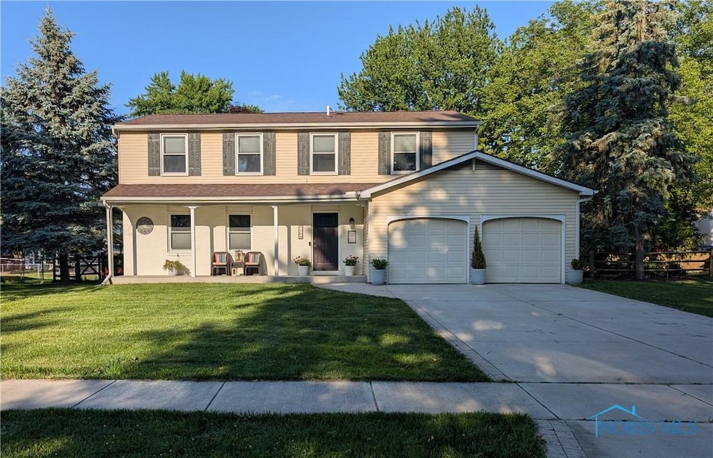 1768 Cambridge Park E, Maumee, OH 43537 - view of front of property with a porch, a garage, a front lawn, and concrete driveway