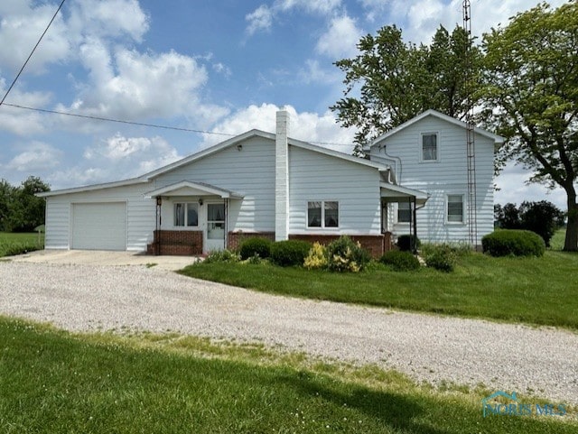18375 County Road R, Alvordton, OH 43501 - view of front of home with gravel driveway, an attached garage, a front lawn, and a chimney