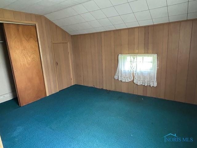 18375 County Road R, Alvordton, OH 43501 - unfurnished bedroom featuring wooden walls, lofted ceiling, carpet, and a closet