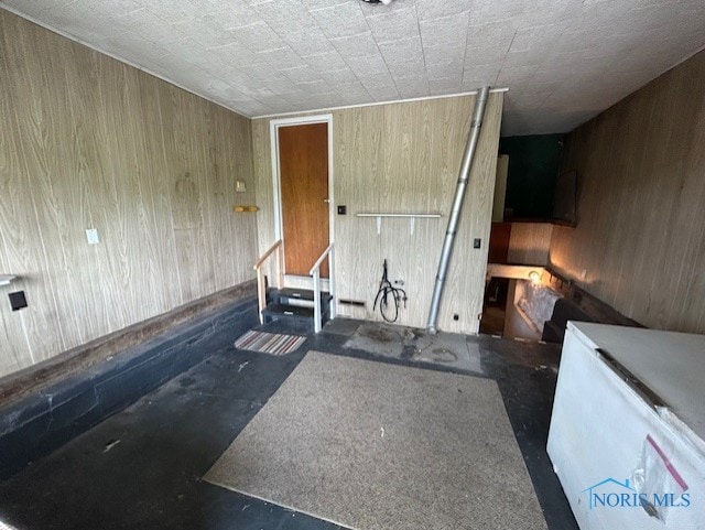 18375 County Road R, Alvordton, OH 43501 - unfurnished room featuring wood walls, concrete floors, and stairs