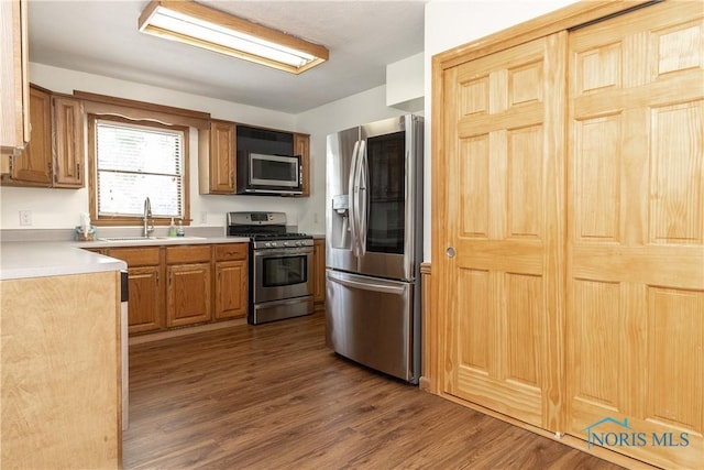 512 State St, Elmore, OH 43416 - kitchen with appliances with stainless steel finishes, dark wood finished floors, light countertops, and brown cabinetry