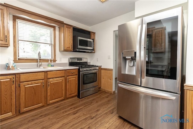 512 State St, Elmore, OH 43416 - kitchen with appliances with stainless steel finishes, wainscoting, wood finished floors, light countertops, and brown cabinets
