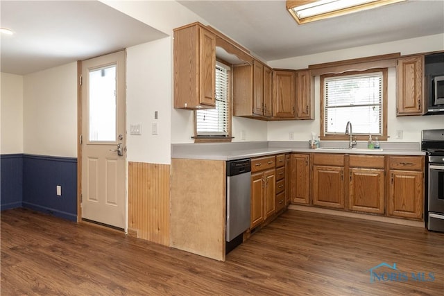 512 State St, Elmore, OH 43416 - kitchen with appliances with stainless steel finishes, wainscoting, dark wood-type flooring, light countertops, and brown cabinets