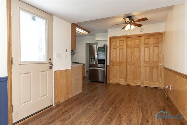 512 State St, Elmore, OH 43416 - kitchen featuring stainless steel fridge, a wainscoted wall, a ceiling fan, dark wood-type flooring, and wooden walls